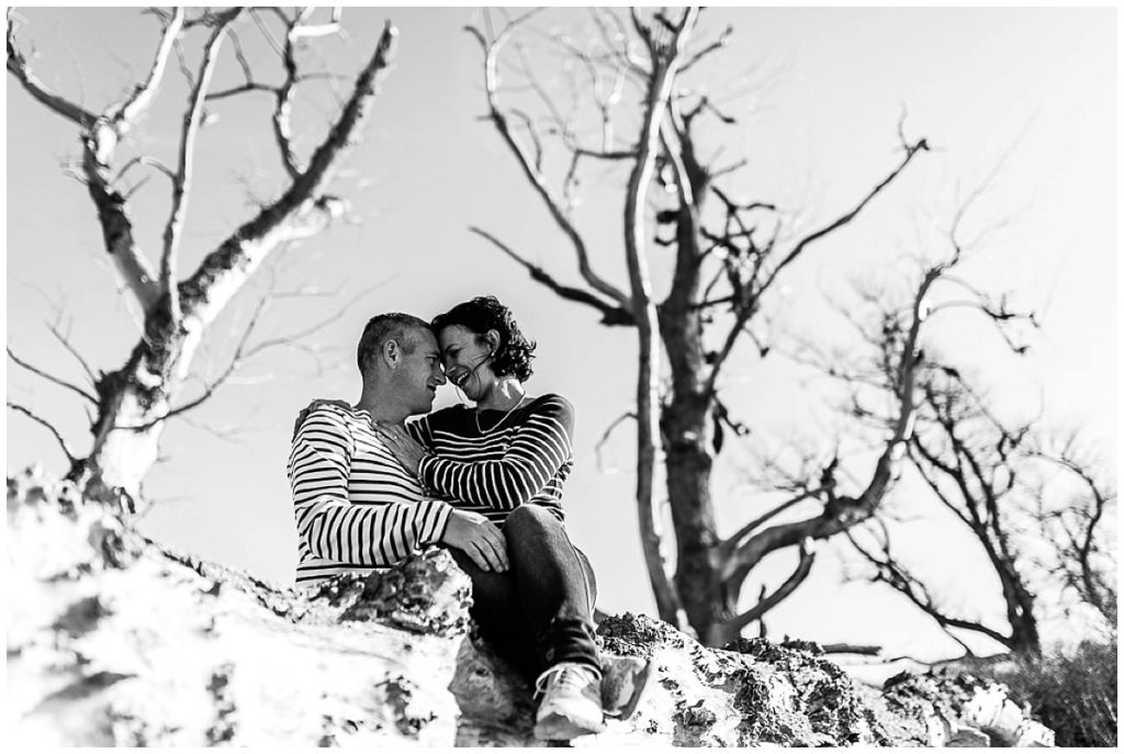 couple qui se regarde sur un tronc d'arbre