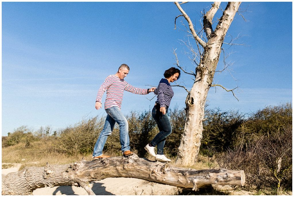 couple qui marche sur un tronc d'arbre