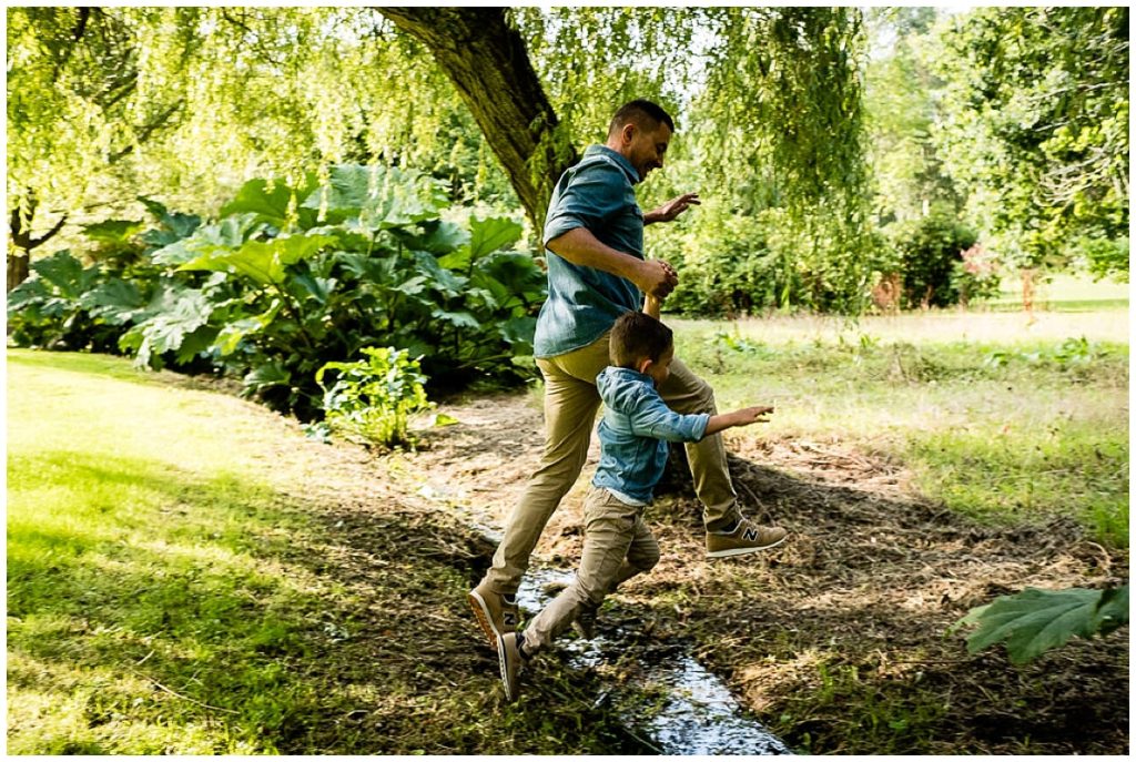 papa qui saute par dessus un ruisseau avec son fils