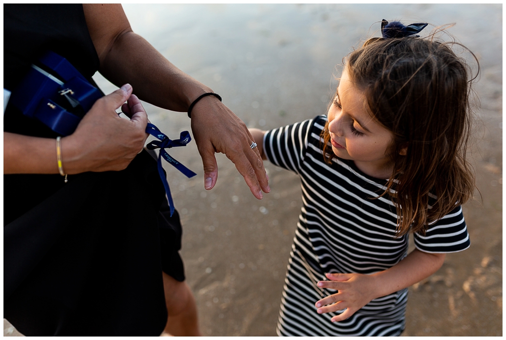 petite fille qui admire la bague de fiançailles de sa maman, audrey guyon photographe mariage en normandie