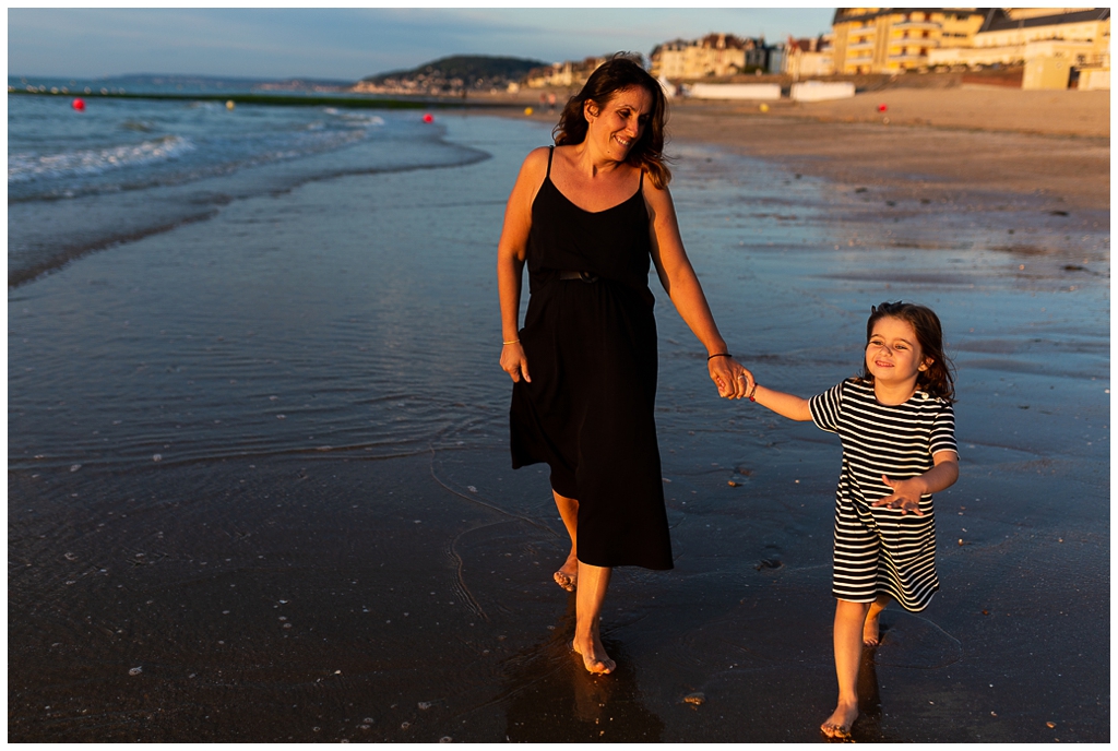 maman et sa fille qui marche main dans la main sur la plage de cabourg